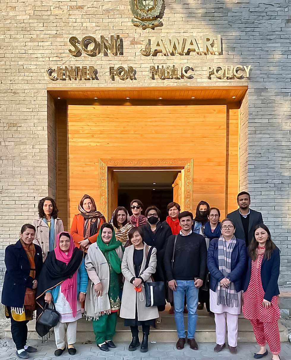 Group of males and female UN Women staff standing in front of a government building call Center for public policy