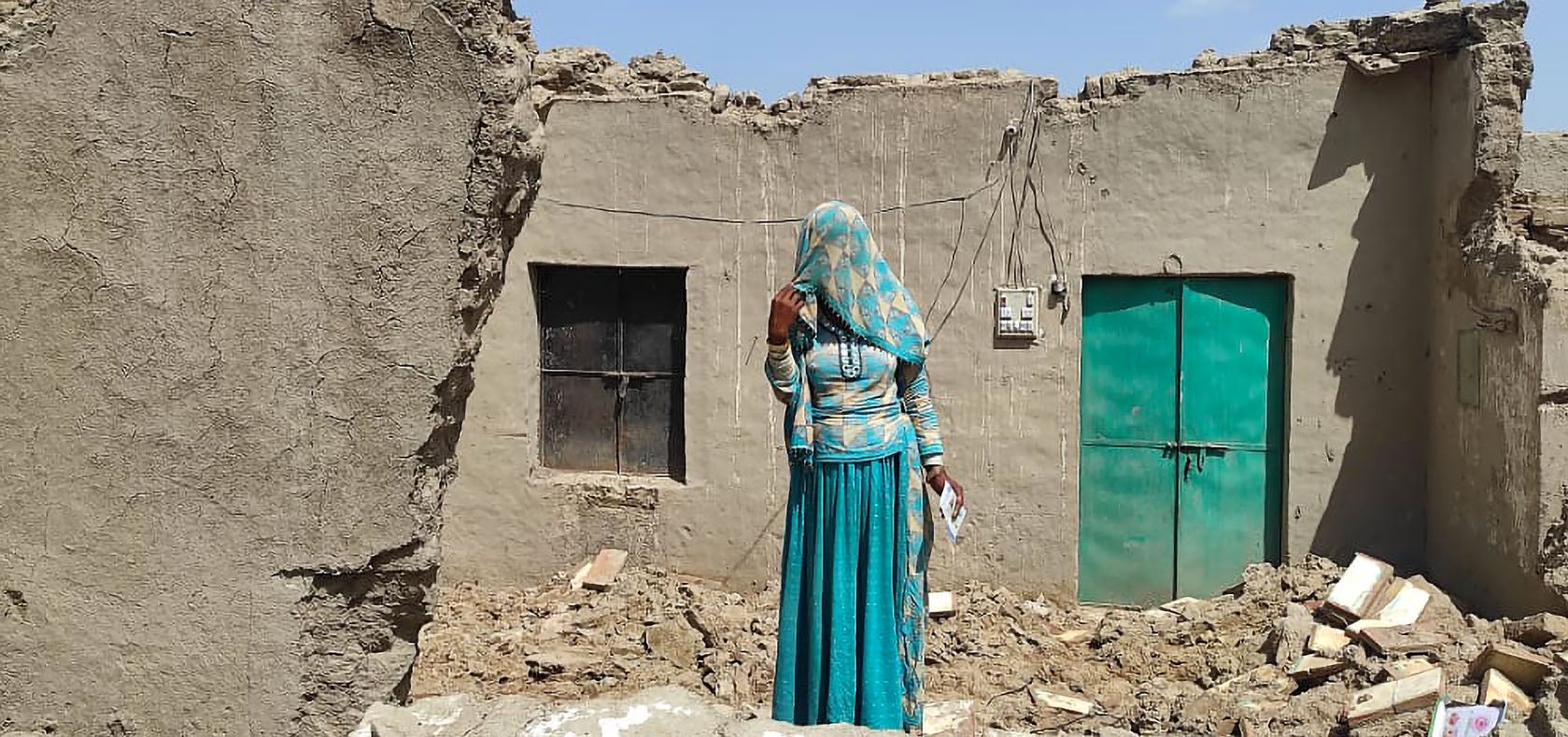 Kavita* stands on a pile of rubish that used to be her home. Photo: UN Women/Kapil Dev